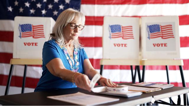 A poll worker sets up a table at a voting place.